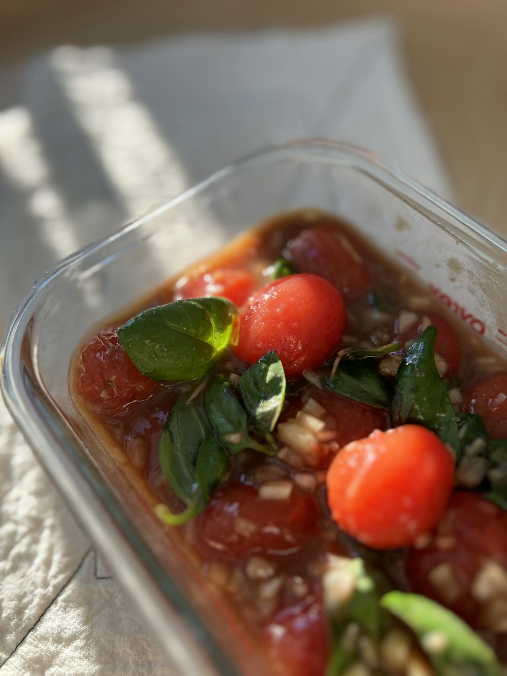 a plastic container filled with tomatoes and other vegetables