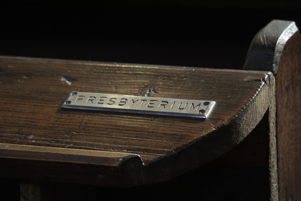 a close up of a wooden bench with a sign on it