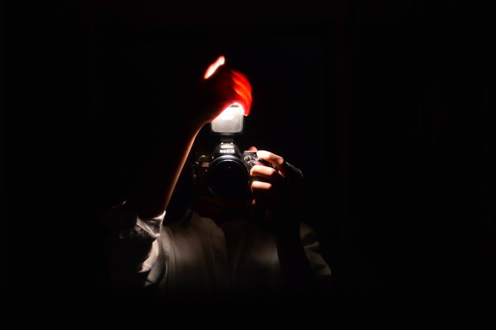 a person holding a camera in the dark