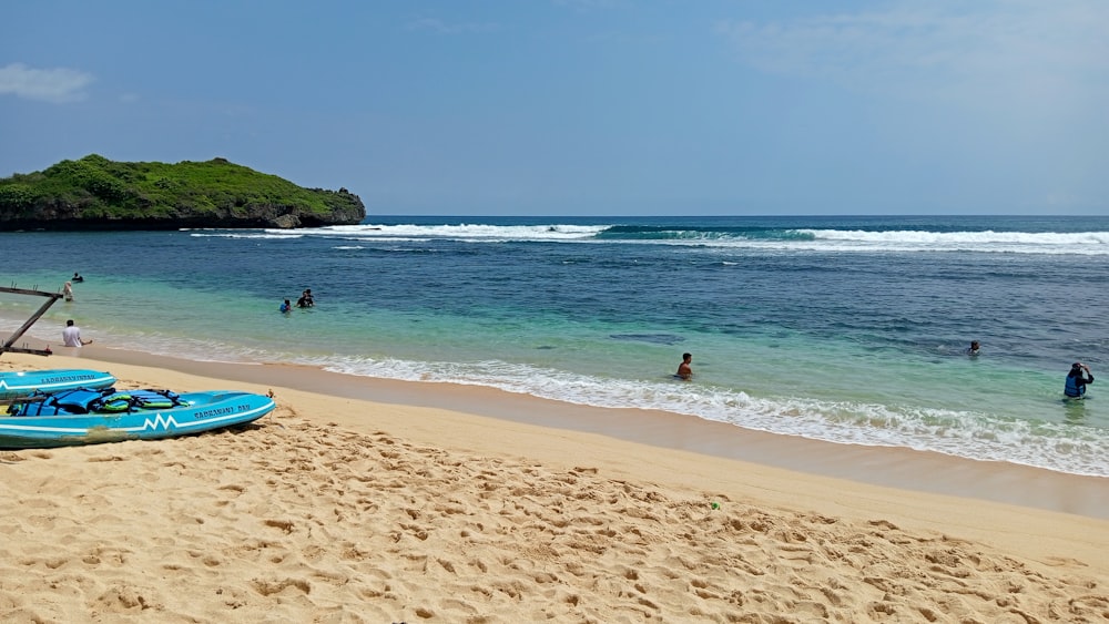 a blue surfboard sitting on top of a sandy beach