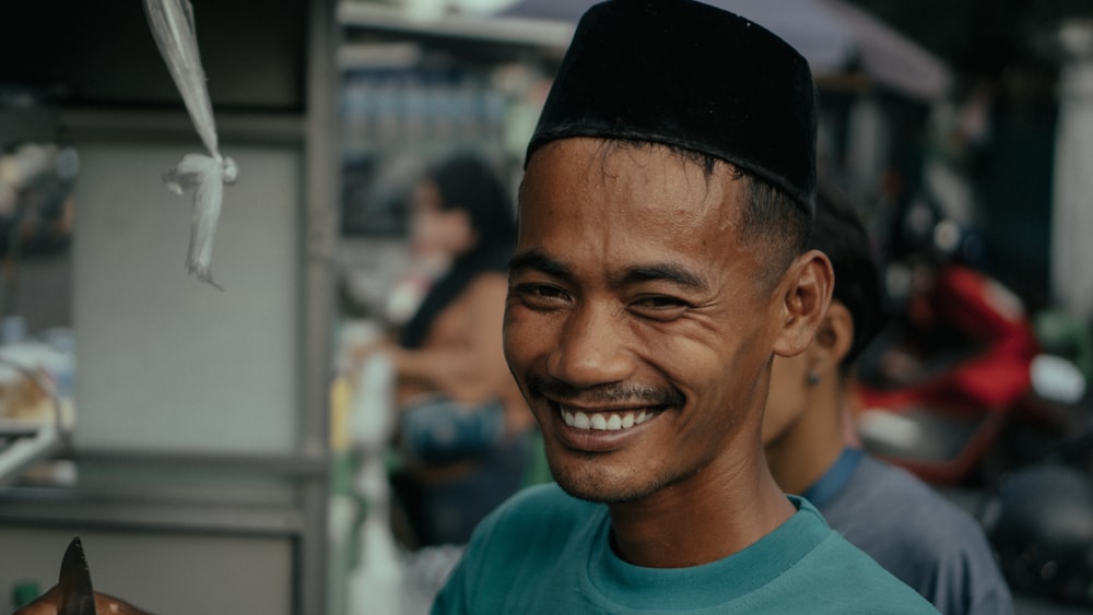 a man smiling while holding a knife in his hand