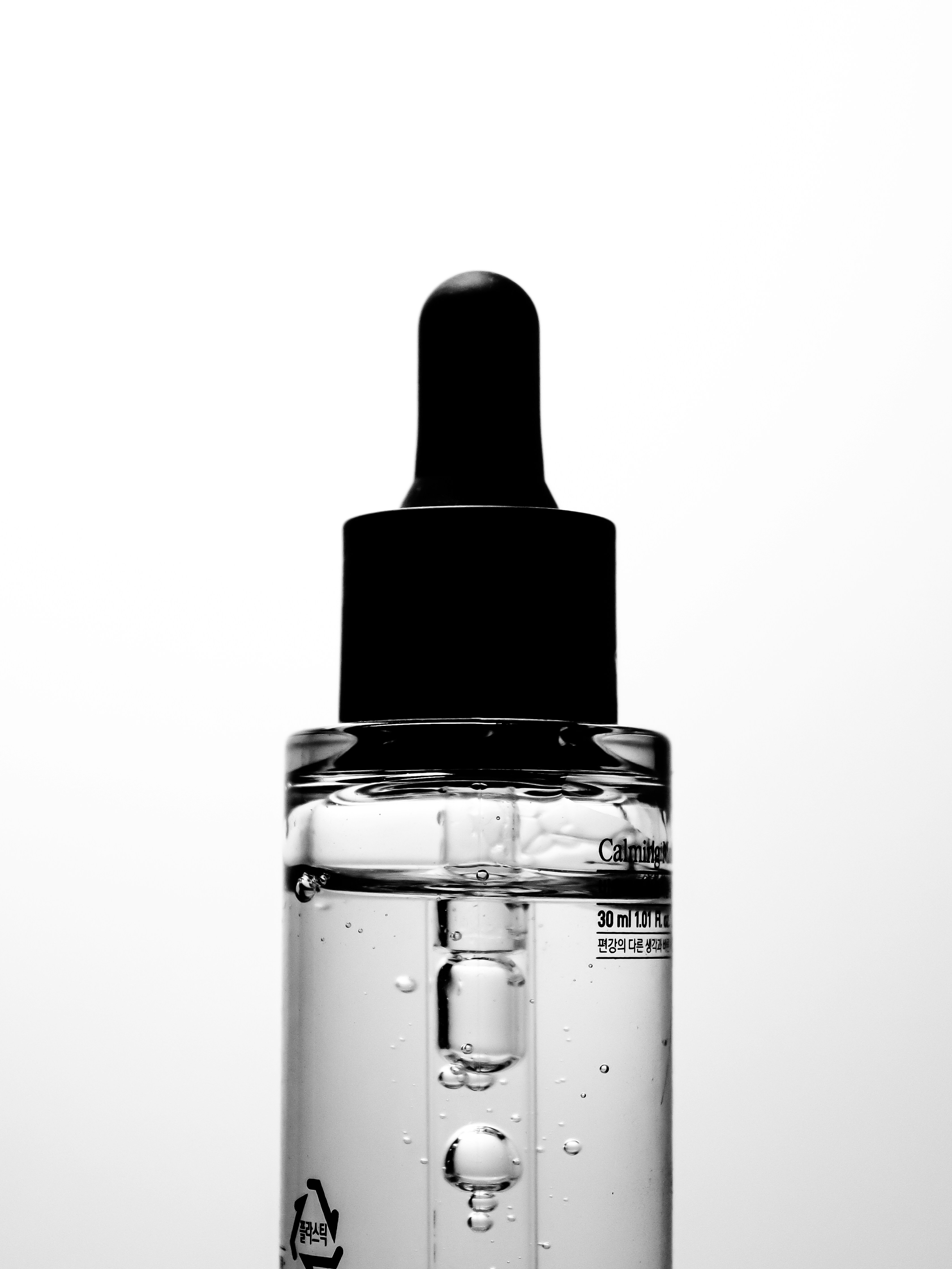 Primer bottle with clear gel formula on dark background professional product photography