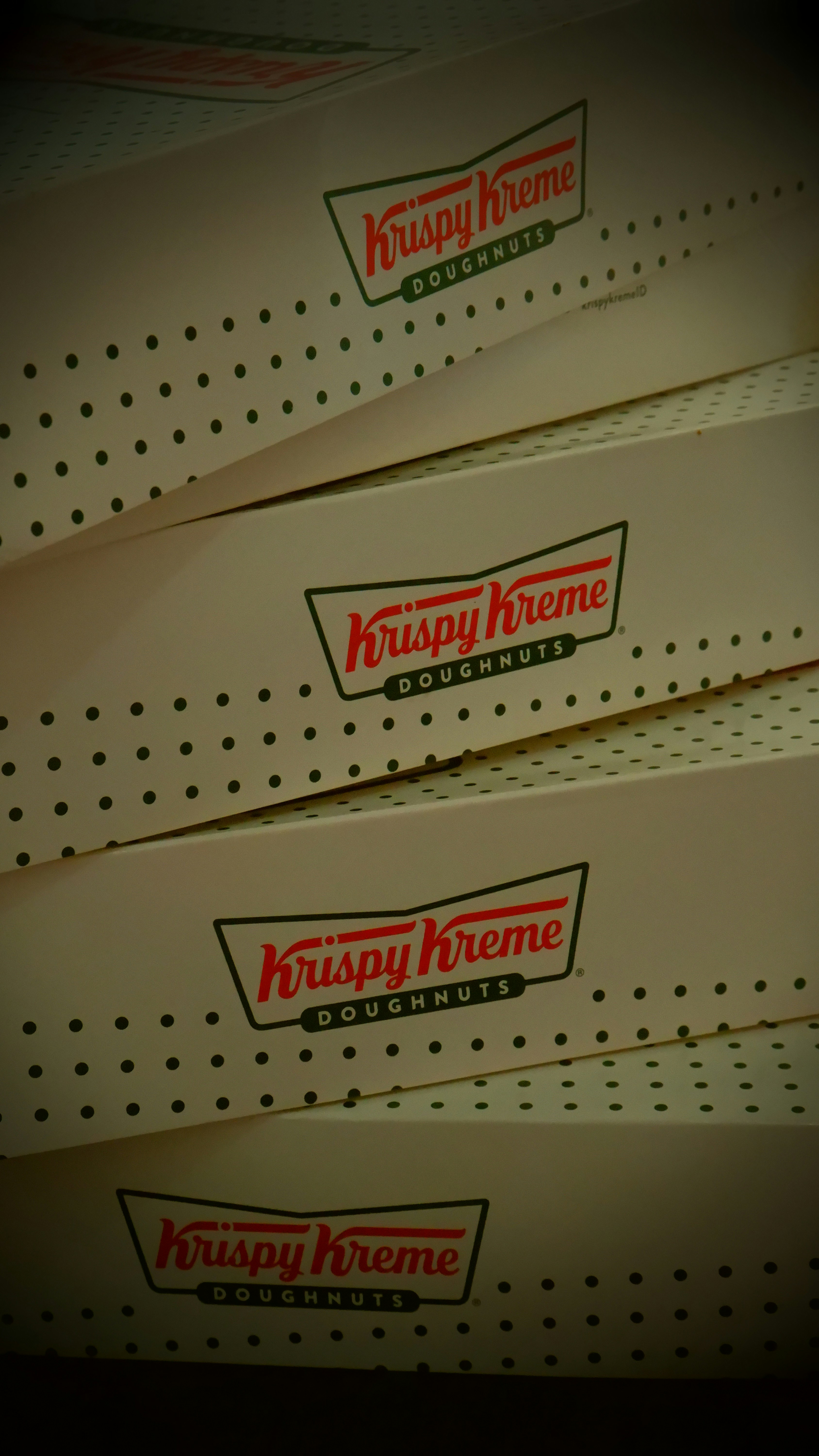 three boxes of krispy kreme sitting on a shelf