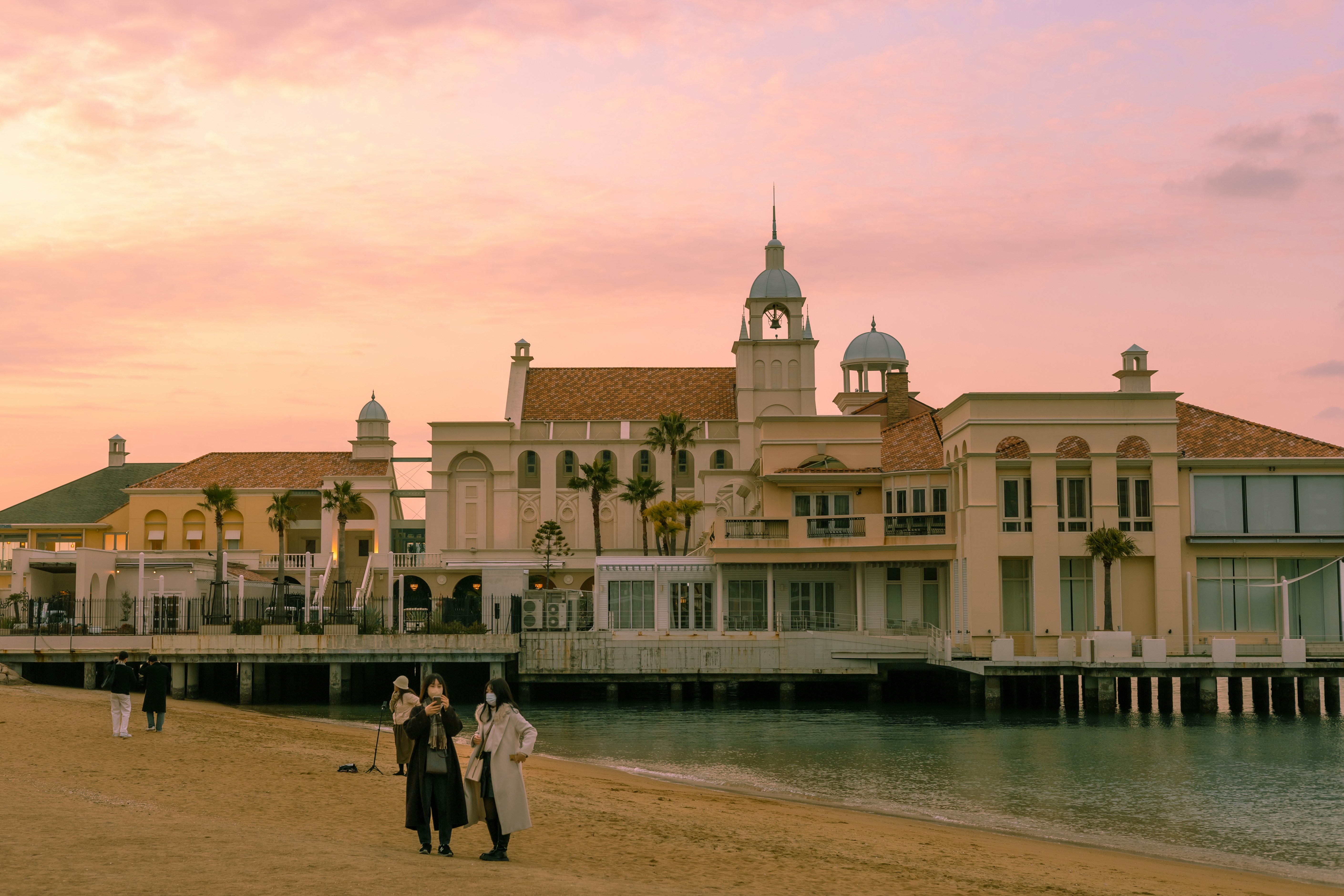 a group of people standing on top of a sandy beach
