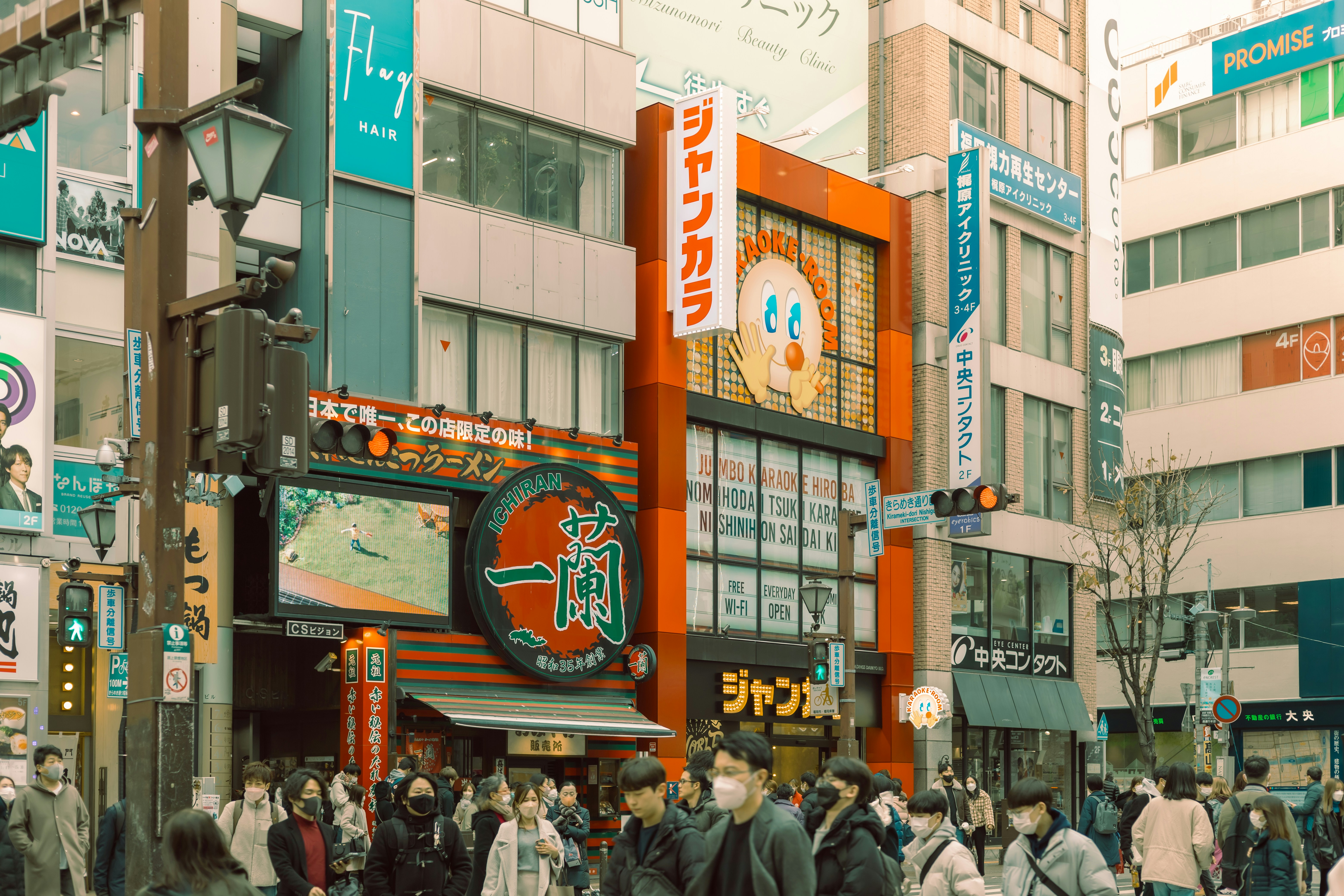 a group of people walking down a street next to tall buildings