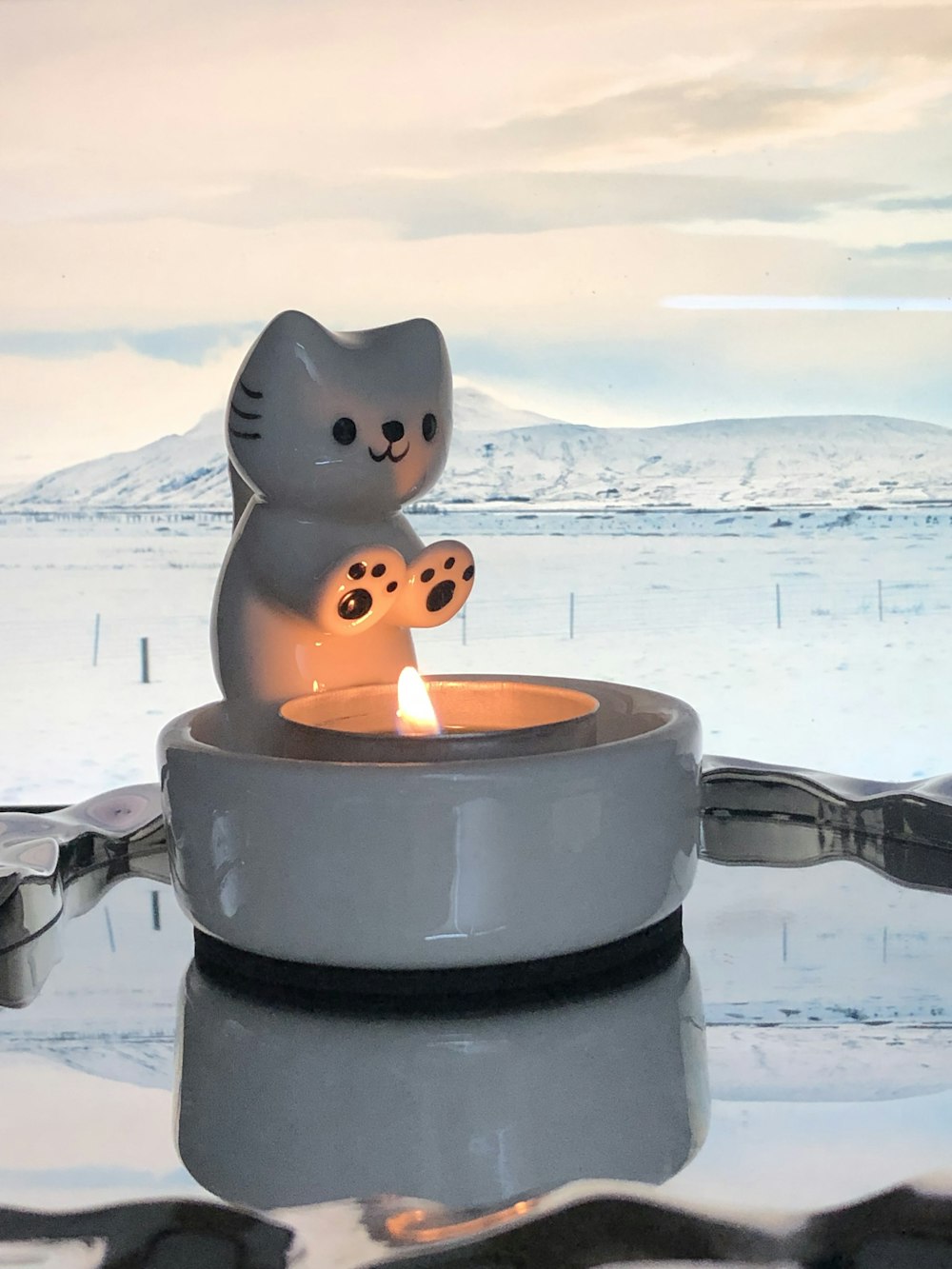 a cat candle holder sitting on top of a table