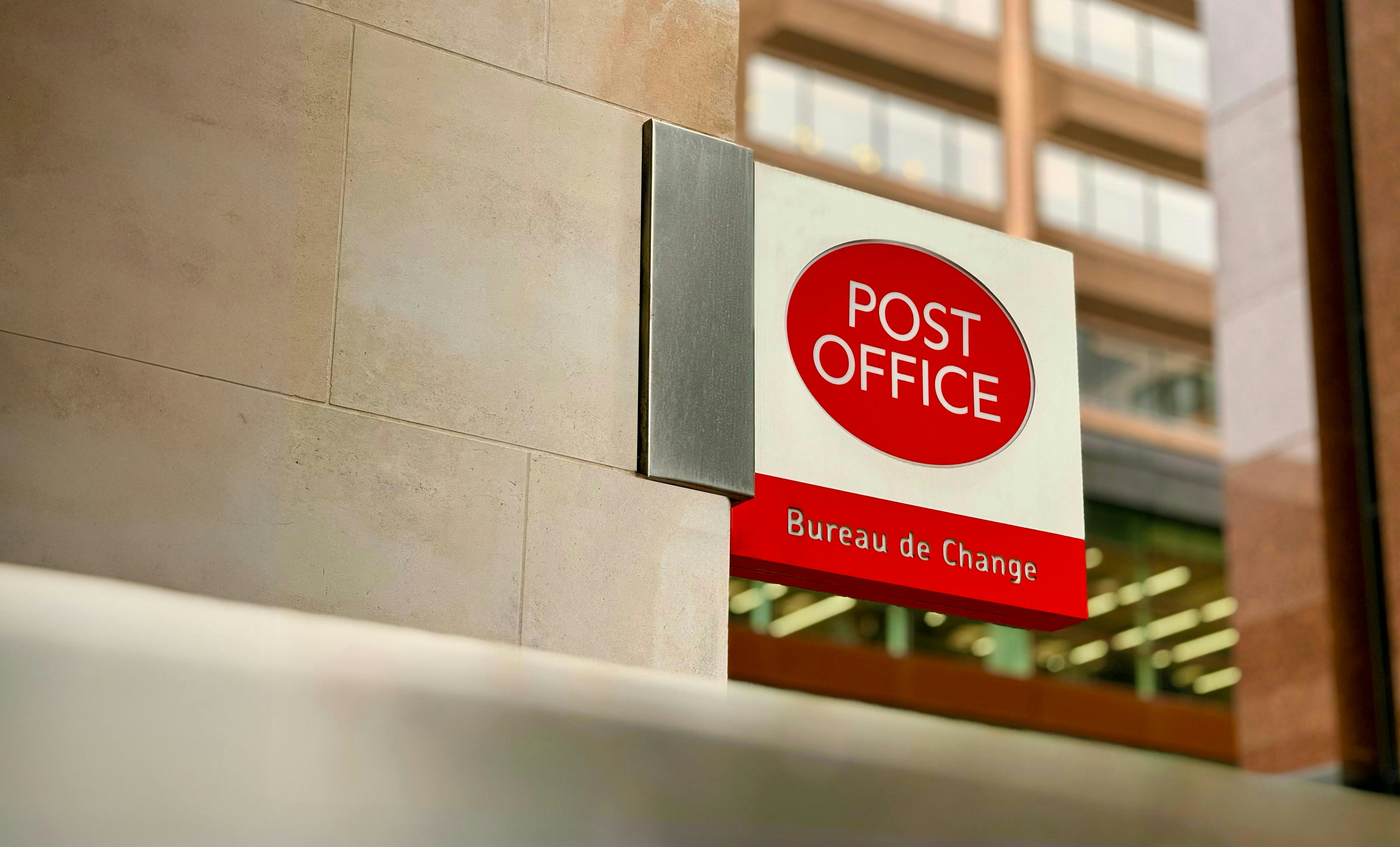 a post office sign on the side of a building, UK Post Office by The Royal Mail