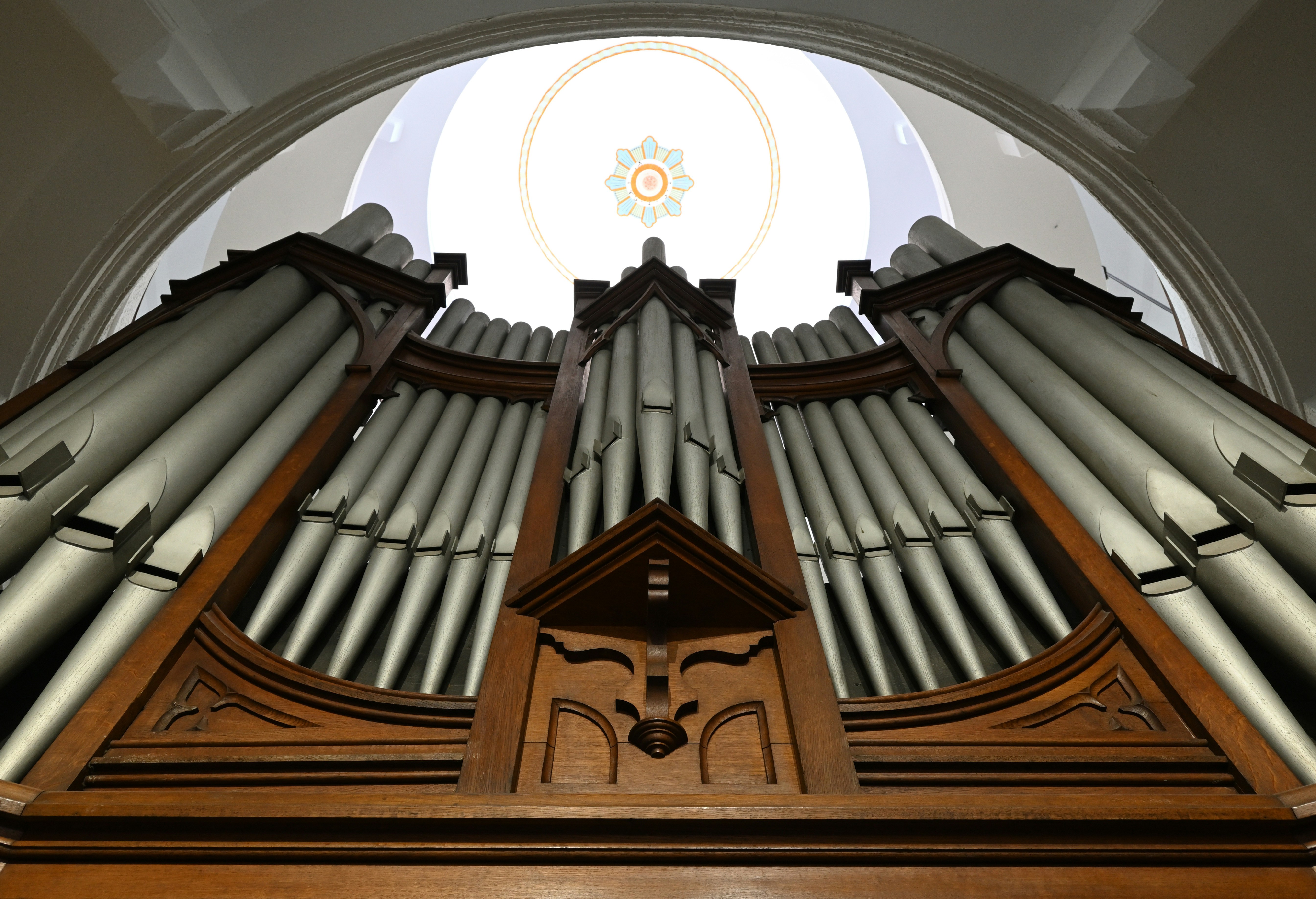 a pipe organ in a church with a circular window