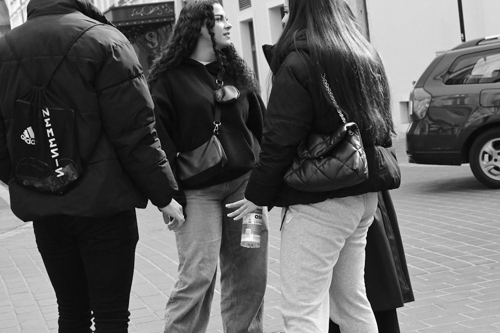 a group of people standing next to each other on a sidewalk