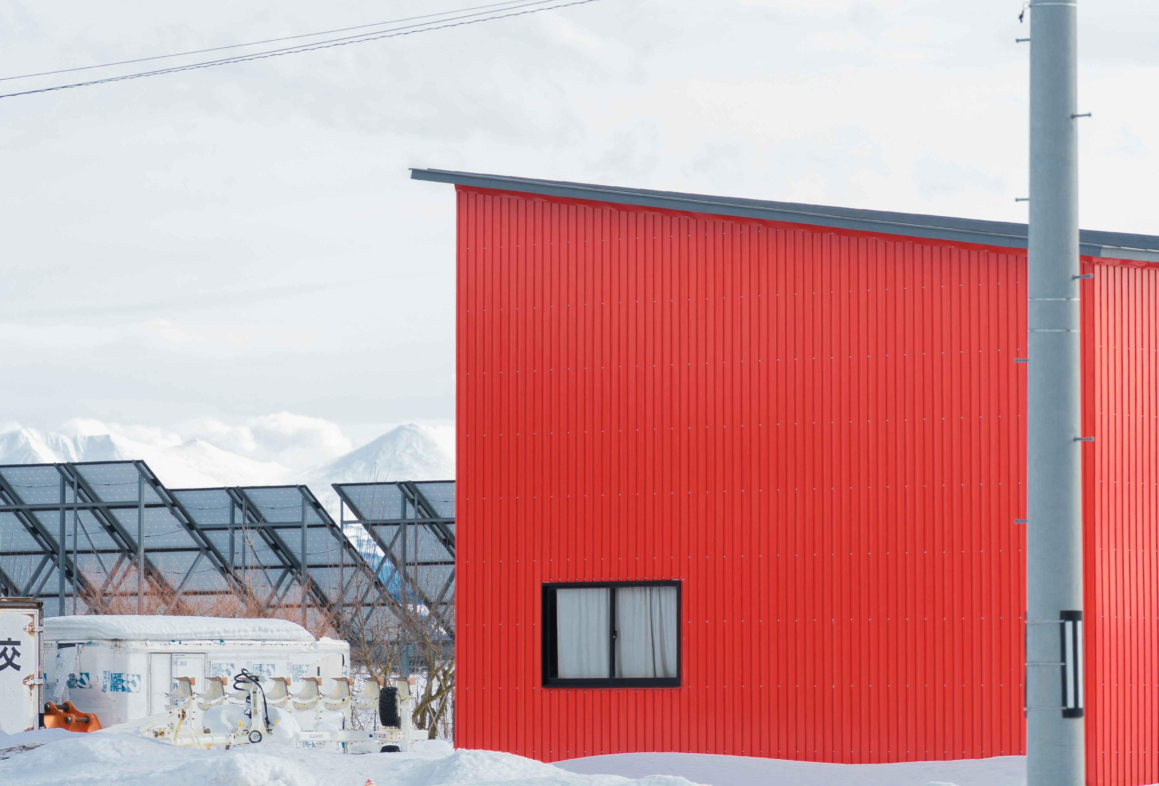 a red building sitting next to a snow covered field