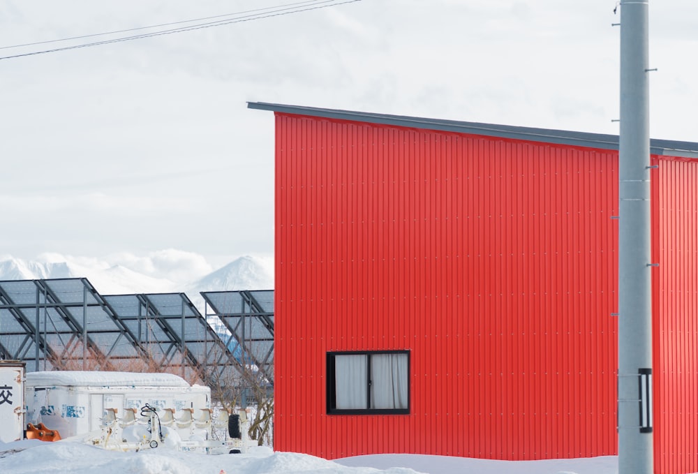 a red building sitting next to a snow covered field