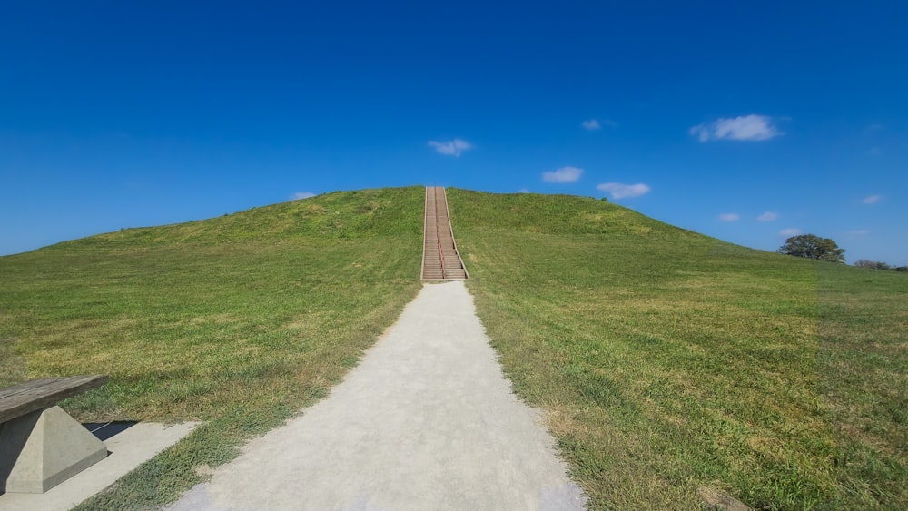 un banc assis au sommet d’une colline couverte d’herbe