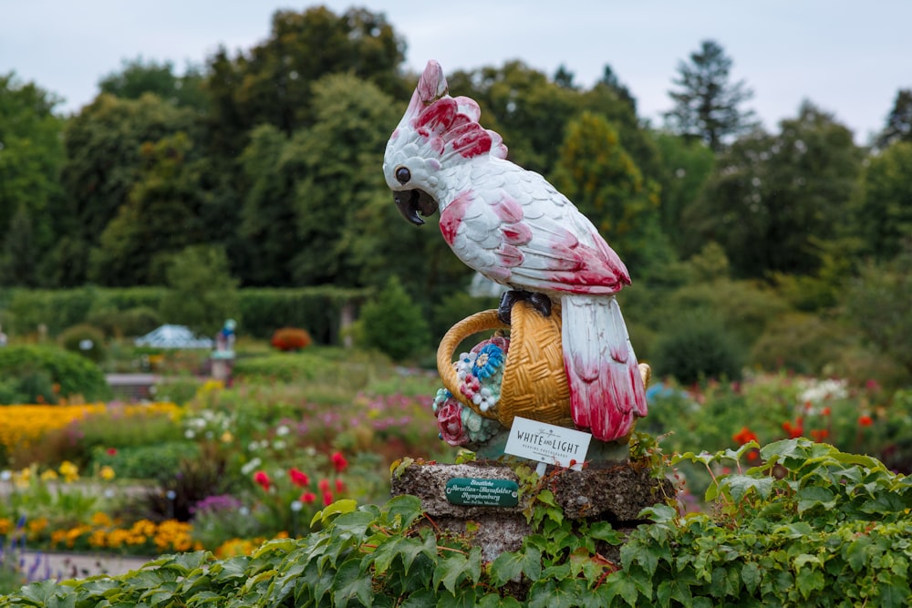 a bird statue sitting on top of a lush green field