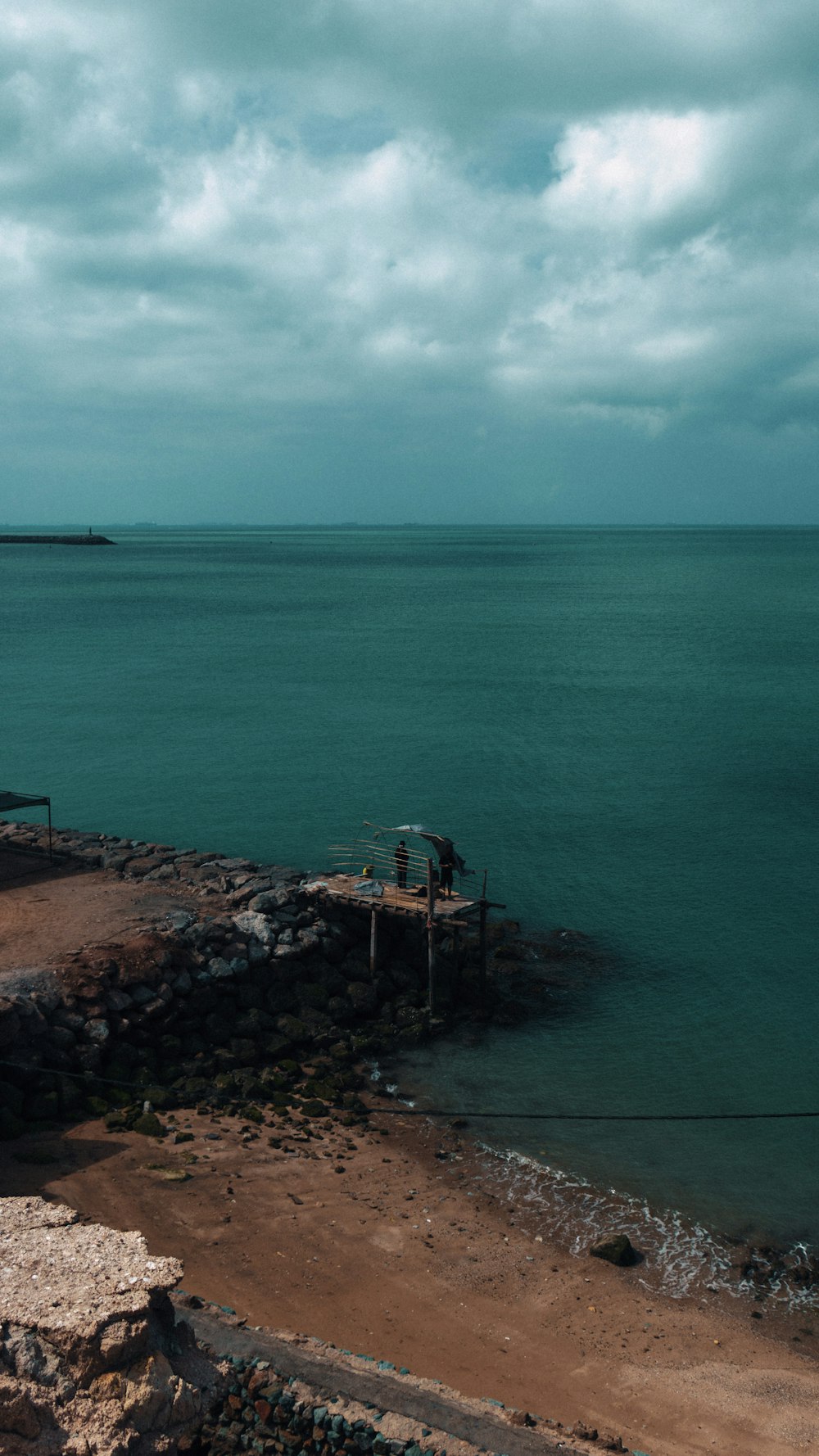 a couple of people standing on top of a pier