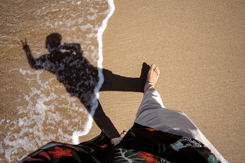 a person standing on a beach next to the ocean