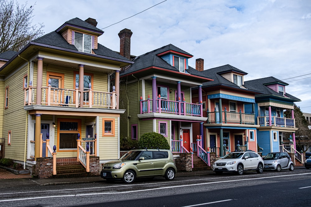 a row of multi - colored houses on a street corner