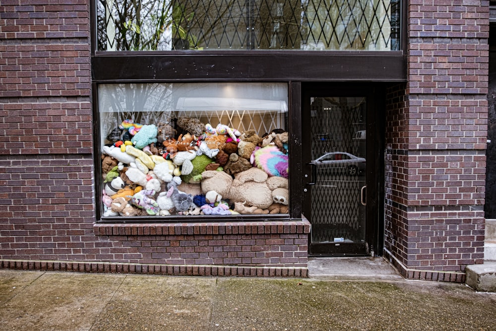 a pile of stuffed animals sitting inside of a window