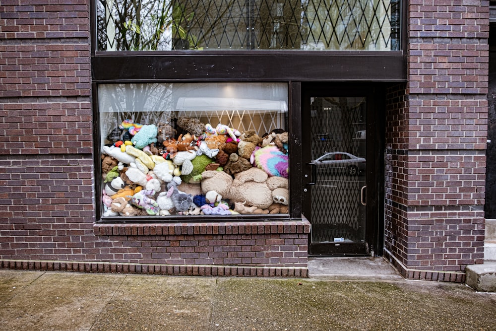 un tas d’animaux en peluche assis à l’intérieur d’une fenêtre