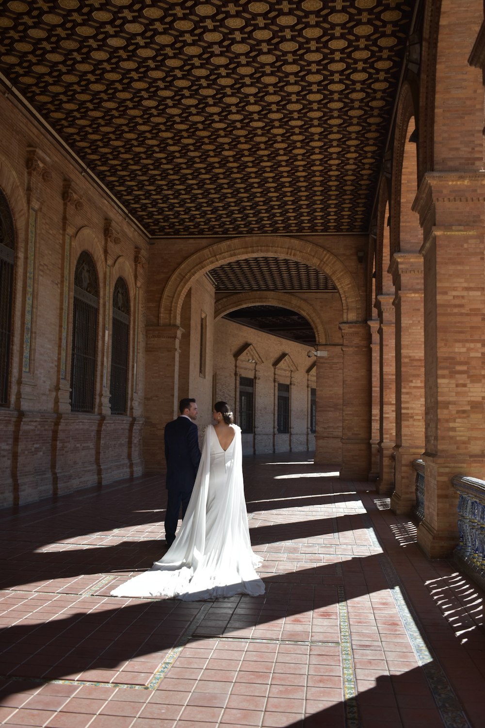 una novia y un novio de pie en un arco