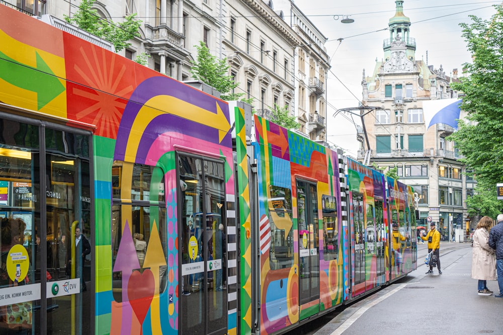 a colorful train is parked on the side of the road