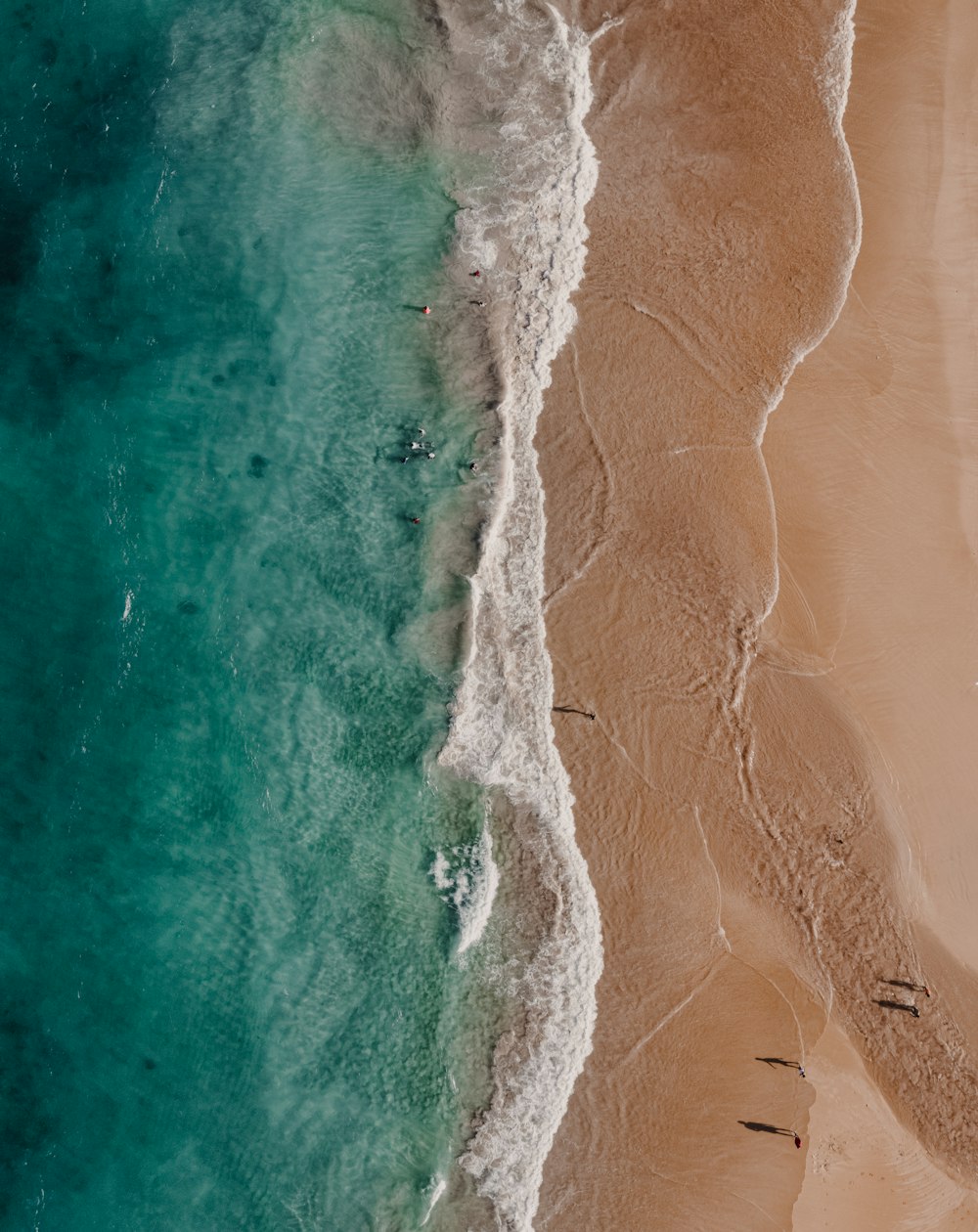 Una vista aérea de una playa con gente en el agua