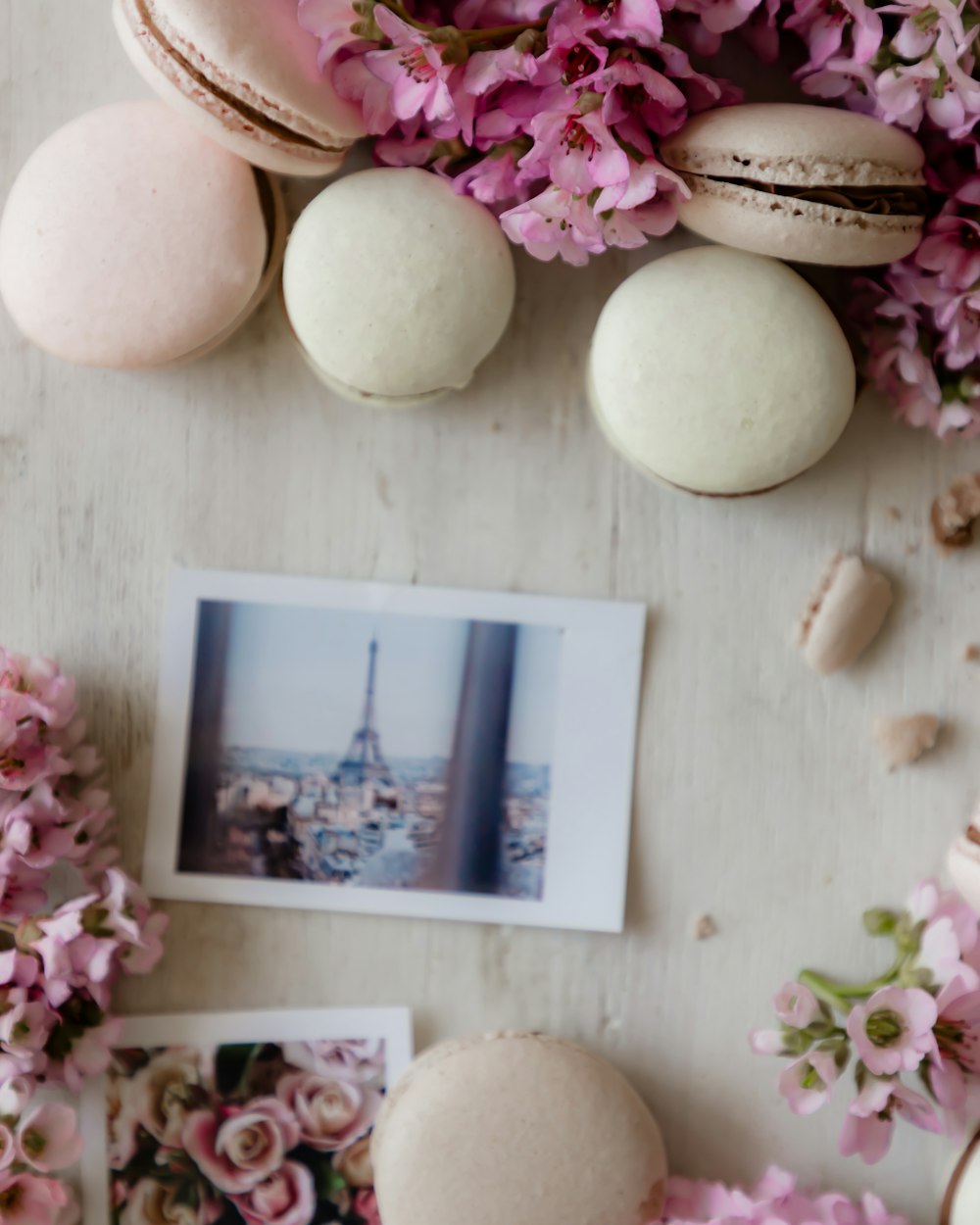 uma mesa coberta com macarons e flores cor-de-rosa