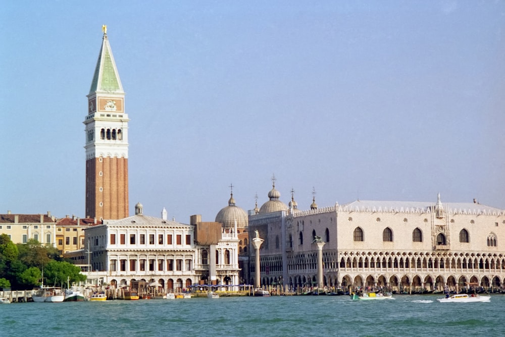 un grande edificio con una torre dell'orologio accanto a uno specchio d'acqua