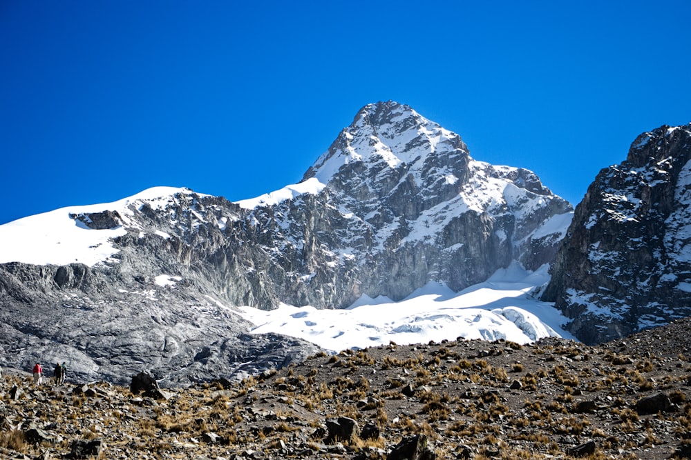 a group of people hiking up the side of a snow covered mountain