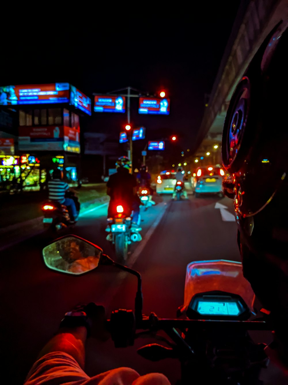 a man riding a motorcycle down a street at night