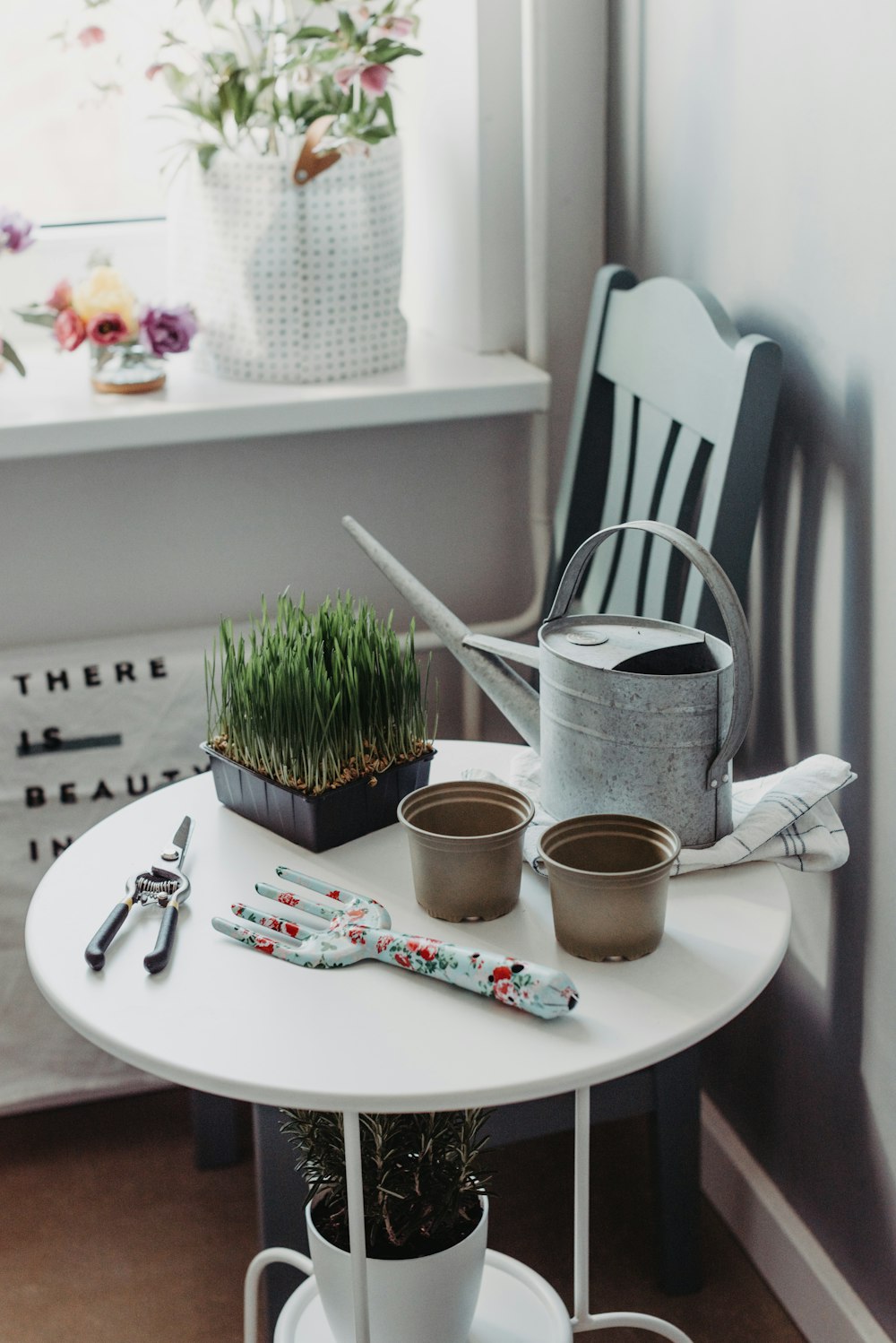 a white table topped with potted plants next to a window