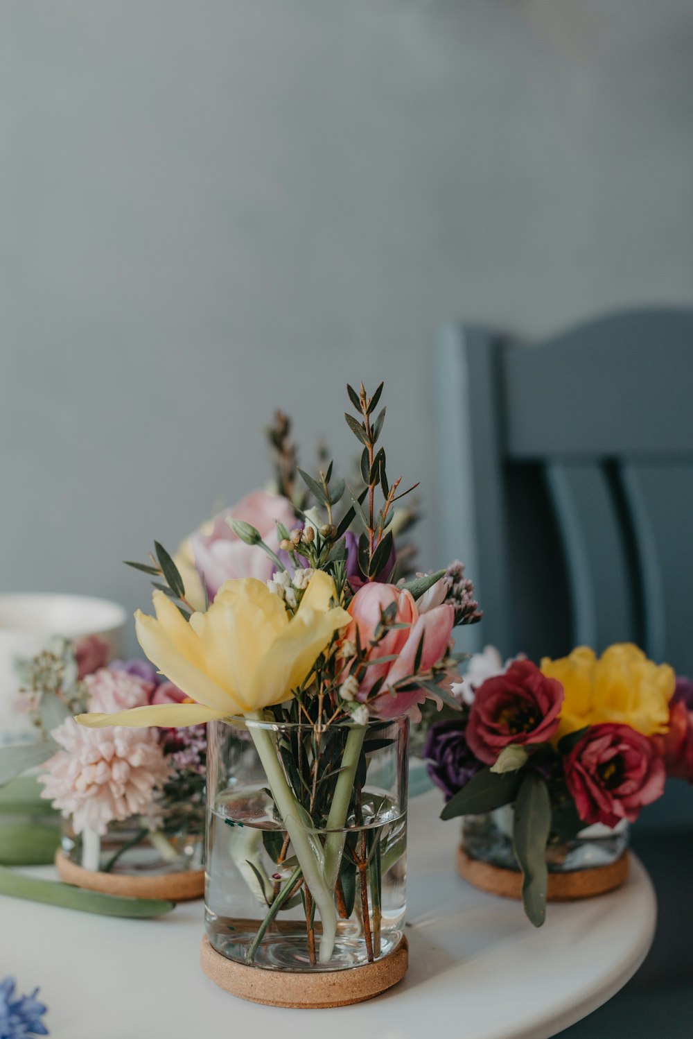 a white table topped with vases filled with flowers