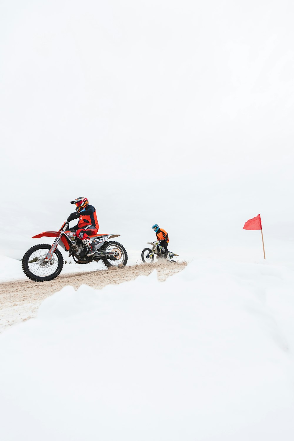 a man riding a dirt bike on top of a snow covered slope