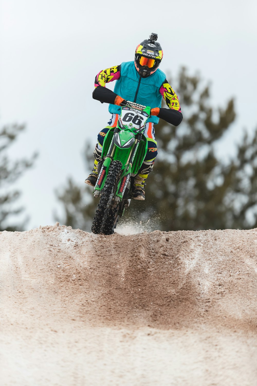 a man riding a dirt bike on top of a dirt hill