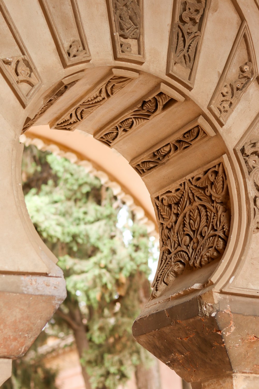 a close up of an arch with a tree in the background