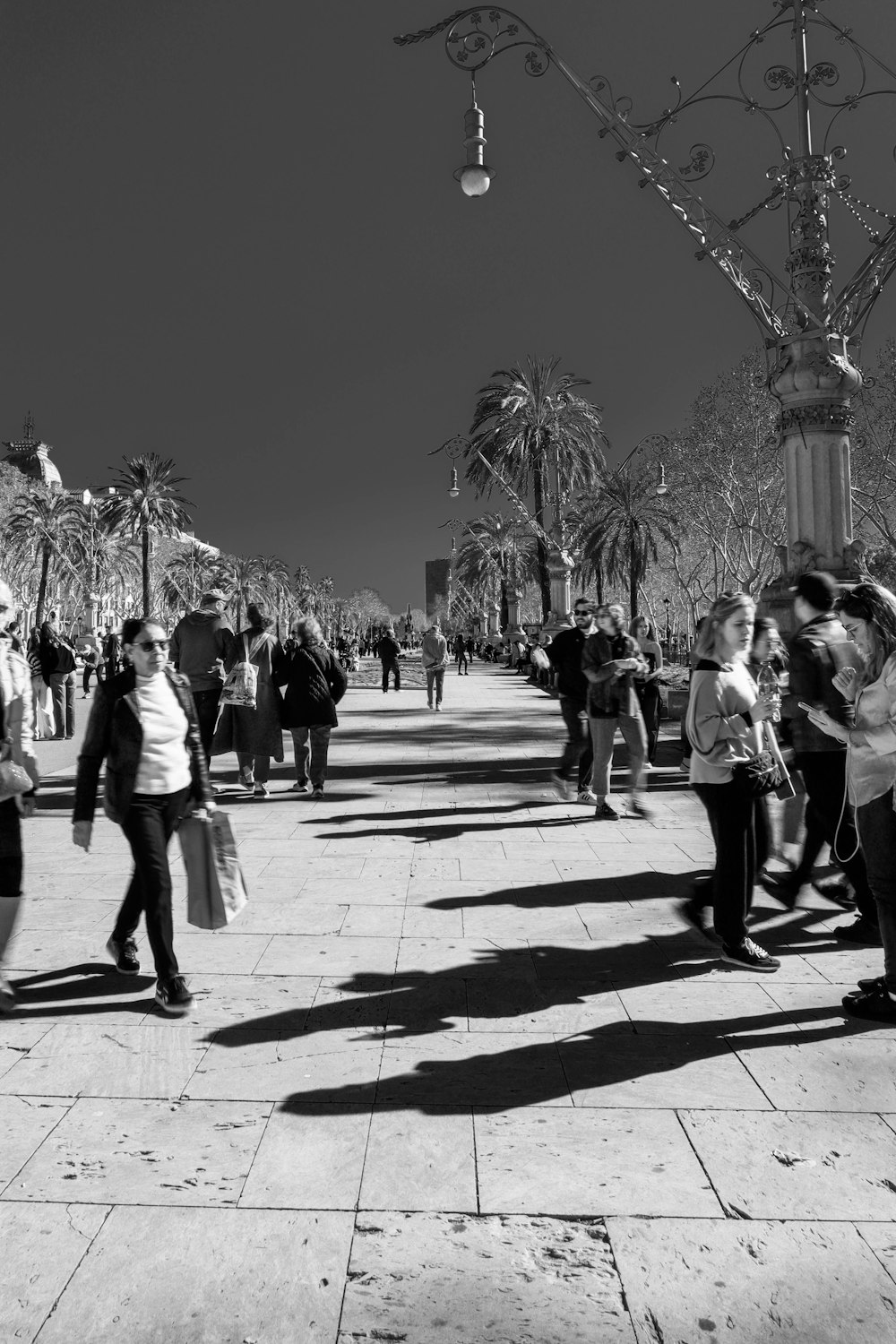 Una foto en blanco y negro de personas caminando por una acera