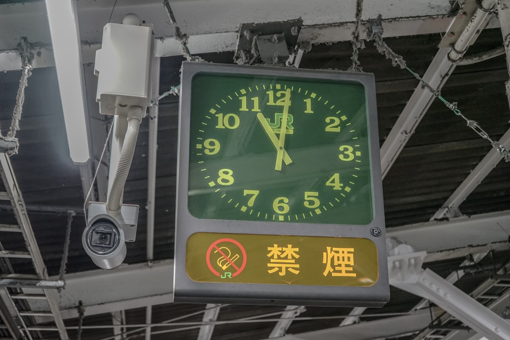 a clock hanging from the ceiling of a building