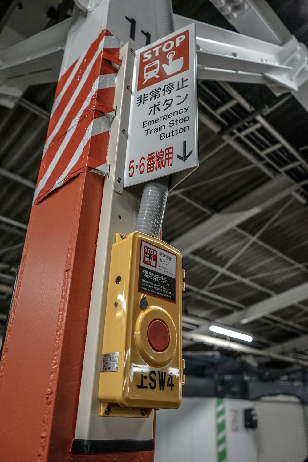 a red and white sign on a pole in a building