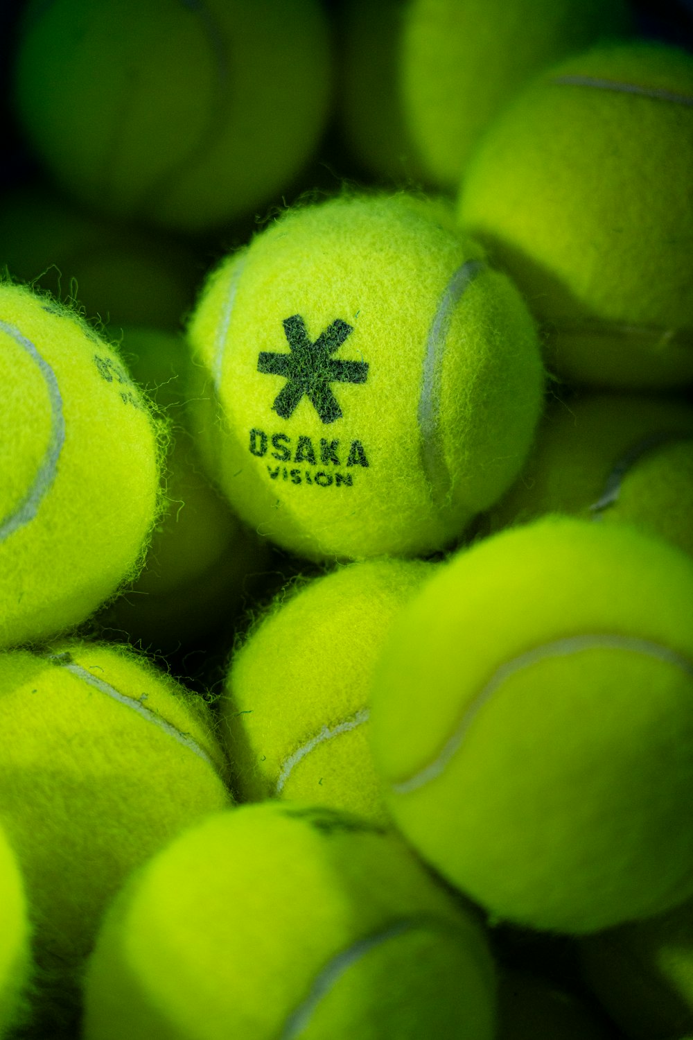 a pile of tennis balls with a logo on them