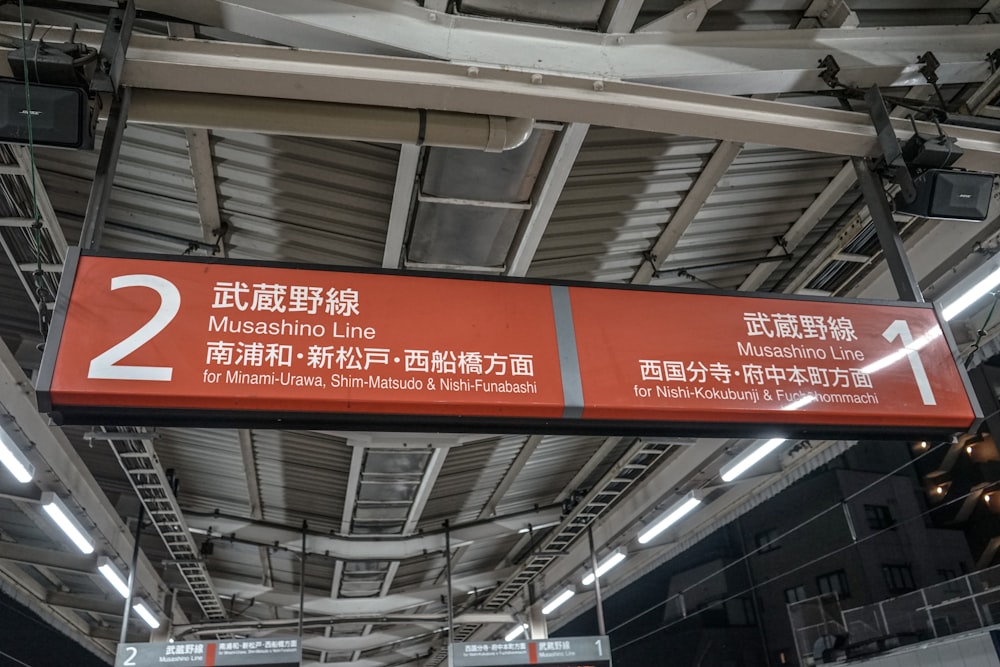 a red sign hanging from the ceiling of a building