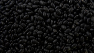 a pile of black beans sitting on top of a table