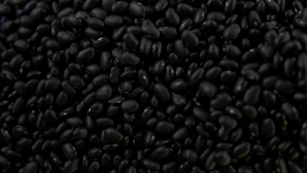 a pile of black beans sitting on top of a table