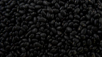 a pile of black beans sitting on top of a table