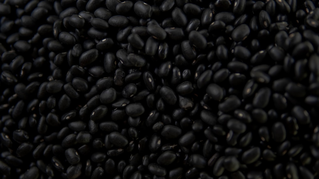 a pile of black beans sitting on top of a table