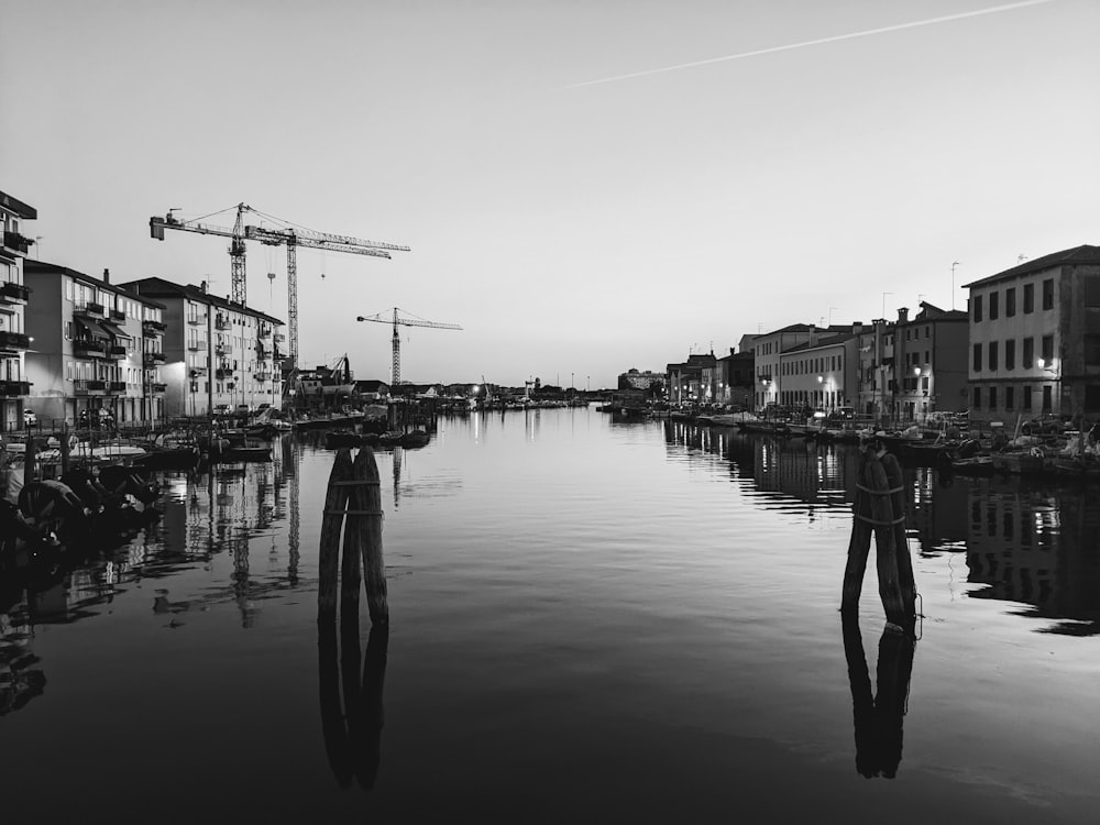 a black and white photo of a river with buildings