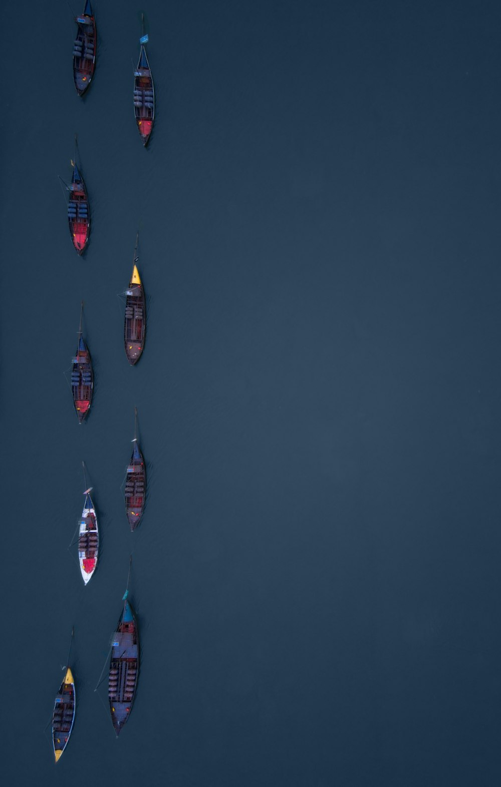 un groupe de petits bateaux flottant au-dessus d’un plan d’eau