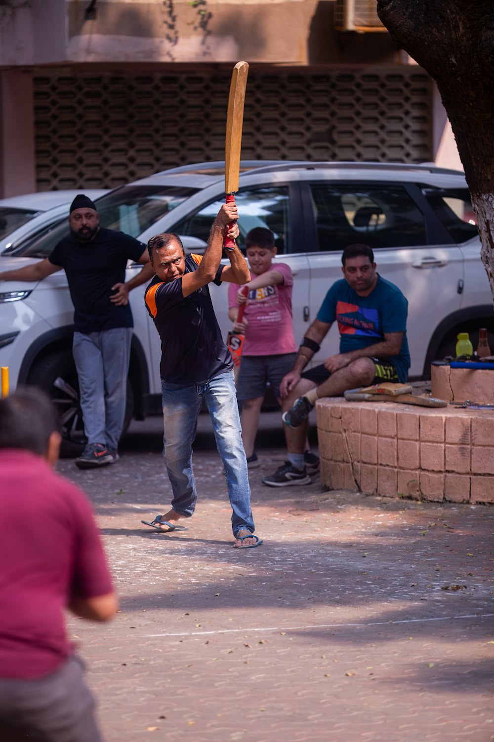 a man holding a baseball bat on a street