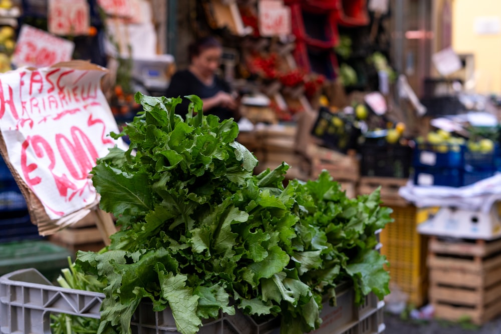 una canasta llena de verduras de hoja verde a la venta