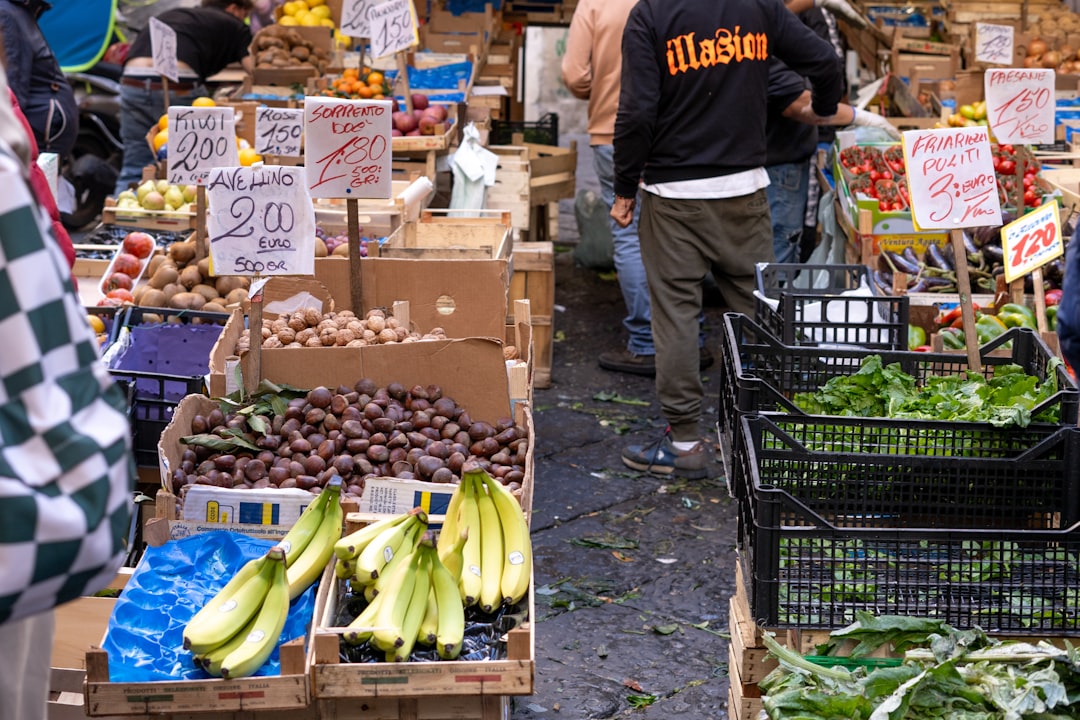 a group of people shopping at an outdoor market,