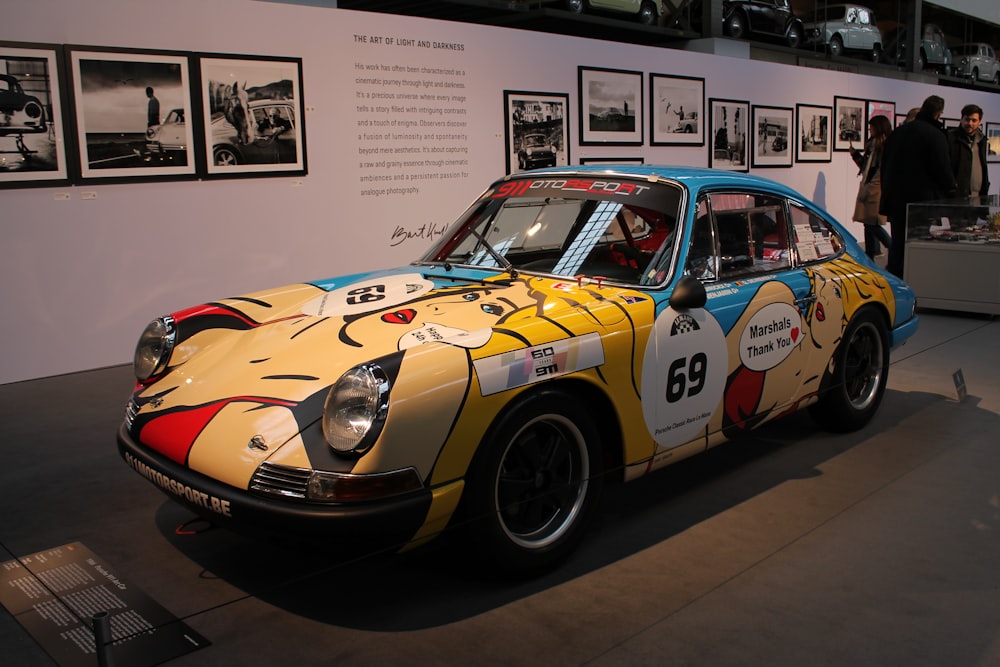 a yellow and blue race car on display in a museum