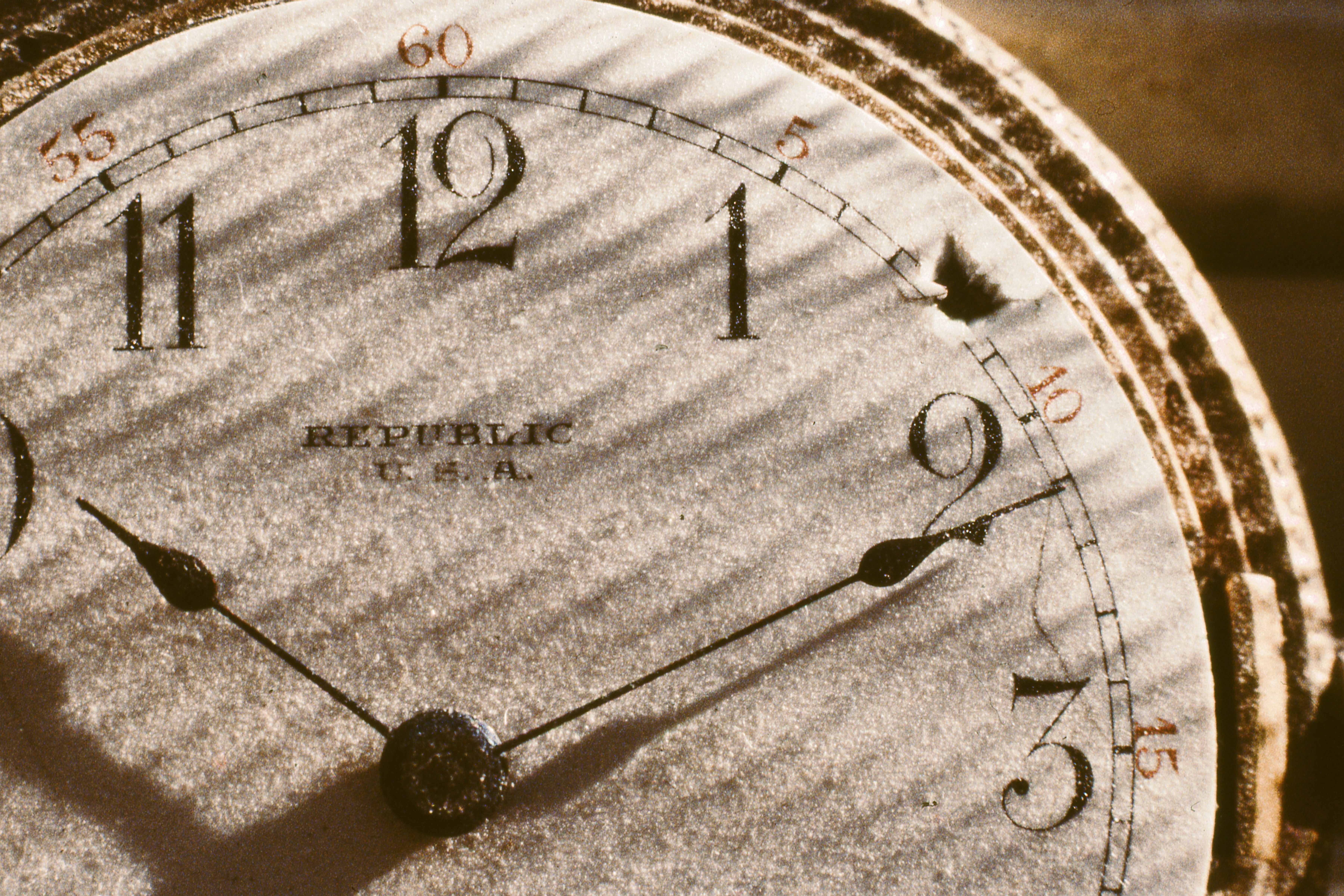 a close up of a clock face with a shadow